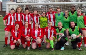 Ladies football team in front of goal posts.